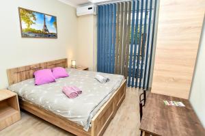 a small bedroom with a bed with purple pillows at Hotel MASPINDZELO in Kutaisi