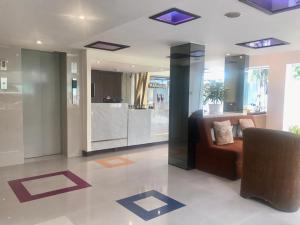 a living room with a couch and a kitchen at Paradiso Boutique Suites in Bangkok