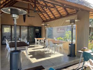 a patio with a table and chairs and a dining room at Lindiwe Safari Lodge in Hoedspruit
