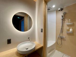 a bathroom with a white sink and a mirror at TABITABI KANOE MITSU in Kyoto