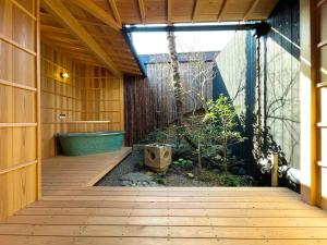 a bathroom with a tub and a wooden walkway at TABITABI KANOE MITSU in Kyoto