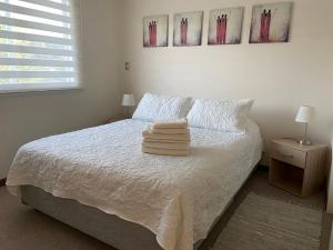 1 dormitorio con 1 cama con 2 toallas en Casa Condominio Los Robles II, en Pucón