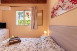 a bedroom with a bed and a tv and a window at Casa Vacanza Brucoli Mare 1 in Brucoli