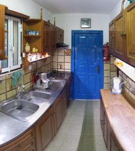 a kitchen with a blue door and a sink at Villa Panorama in Pefkos in Pefki
