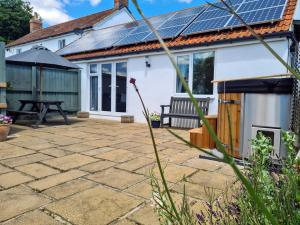 a patio with solar panels on the roof of a house at Thornhills Cottage in Bridgwater