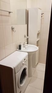 a bathroom with a washing machine and a sink at Apartament Skwer Kosciuszki Morze in Gdynia