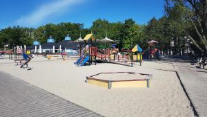 a playground with a play equipment in the sand at Apartament Skwer Kosciuszki Morze in Gdynia
