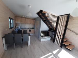uma sala de estar com uma escada e uma sala de jantar e cozinha em Horyzont Bałtyku em Gąski