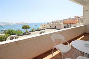 Un balcón con sillas y vista al mar. en Doka Center Apartments, en Sarandë