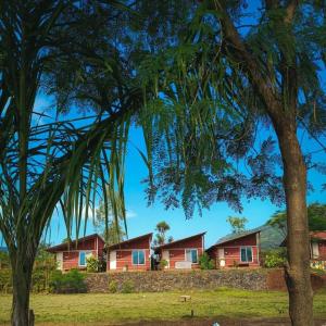 una fila de casas en una colina con un árbol en Mysticstays Resort, en Wai