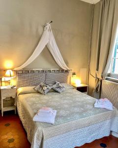 Guest House Santa Giustina Lucca Centro Storico في لوكّا: غرفة نوم بسرير مع مظلة