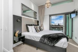 a bedroom with a bed and a large window at Penthouse Glory in Auckland