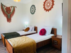 マラトカンボスにあるDimitris placeの白い壁と赤い枕が備わる客室のベッド2台