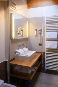 a bathroom with a sink and a mirror at Il Piccolo Dolomiti Resort in Andalo