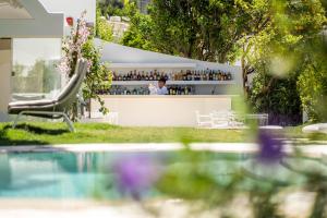 a woman sitting in a chair in front of a bar at Pazziella Garden & Suites in Capri
