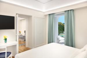 a hotel room with a bed and a balcony at Pazziella Garden & Suites in Capri