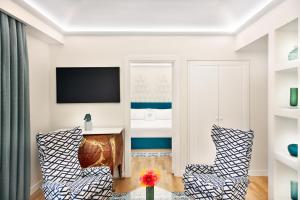 a living room with two chairs and a desk at Pazziella Garden & Suites in Capri