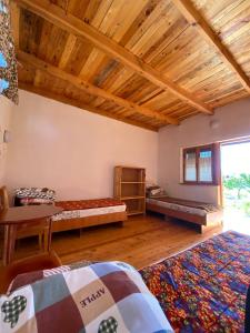 Cette chambre dispose de deux lits et d'un plafond en bois. dans l'établissement Eldos-Ata Eco Hotel, à Tossor