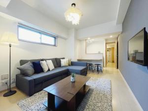 een woonkamer met een bank en een tafel bij bHotel 560 Comfy Elegant 1BR apartment for 4 people in Hiroshima