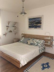 a bedroom with a bed with a wooden headboard at Appartamento Torbole Conca D'Oro in Nago-Torbole