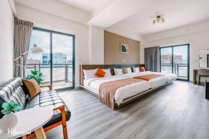 ein Hotelzimmer mit einem Bett und einem Sofa in der Unterkunft Penghu Lemongrass in Magong