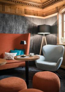 ein Wohnzimmer mit einem Sofa, einem Stuhl und einem Tisch in der Unterkunft Paradies Pure Mountain Resort in Sulden