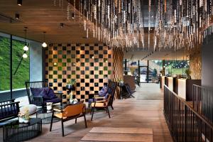 a lobby with chairs and a chandelier at ZillergrundRock Luxury Mountain Resort in Mayrhofen