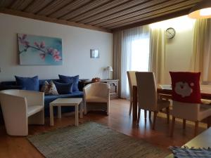 salon z niebieską kanapą i stołem w obiekcie Bhome Gästehaus b&b / Apartments w mieście Neukirchen am Großvenediger