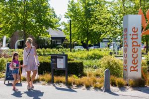 a woman and a young girl walking past a sign at Europarcs Zuiderzee in Biddinghuizen
