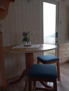 a table with a vase of flowers and two chairs at Dovolená Výr, kemp Výrovice, mobilní dům in Výrovice