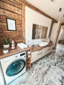 a bathroom with a washing machine and a sink at Ranna Apartment in Võru