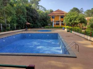 una piscina in un cortile con una casa di Paradisestay Auro Jungle Resort a Pondicherry