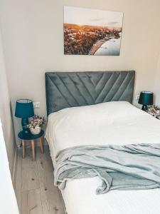 a bedroom with a bed with a green headboard and two lamps at Ranna Apartment in Võru