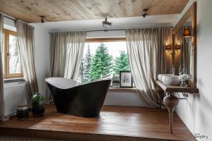 bagno con vasca di fronte a una finestra di Luxury Chalet Villa Gorsky a Poronin