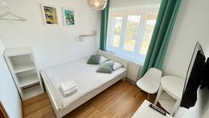 Kleines Zimmer mit einem Bett und einem Fenster in der Unterkunft Fajne Miejsce in Łeba