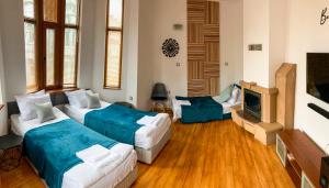 a living room with two beds and a tv at Two Bedroom Apartment -Welcome to Burgas- Top Location, Central Station, Main Walking Street, Sea Garden, near the Beach in Burgas City