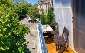 ein Balkon mit einem Tisch und Stühlen auf einem Balkon in der Unterkunft Two Bedroom Apartment - Alexandrovska - Top Location - Central Bus, Train and Marine Stations, next to Sea Garden and Beach in Burgas City