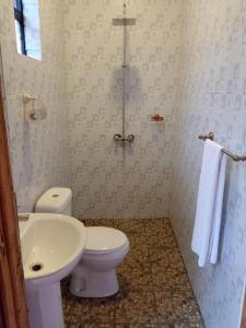 a bathroom with a white toilet and a sink at Stay.Plus Villa Serene Kitale in Kitale