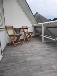 2 Stühle und ein Tisch auf dem Balkon in der Unterkunft Les embruns in Saint-Philibert