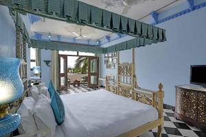 乌代浦Swaroop Vilas - Lake Facing Boutique Hotel的带天篷床的卧室
