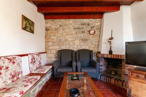 sala de estar con 2 sillas y chimenea en Appto Turístico Tapia 1, en Luces