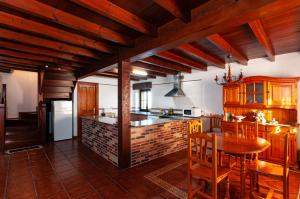una cocina con mesa y una cocina con techos de madera. en Appto Turístico Tapia 1, en Luces