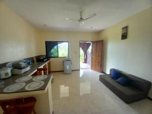 a kitchen and living room with a table and a couch at Teresa house Rental Villa Teresa Philippines in Moalboal