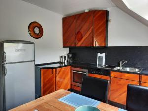 a kitchen with wooden cabinets and a table and a refrigerator at Ferienwohnungen Joop in Biersdorf am See