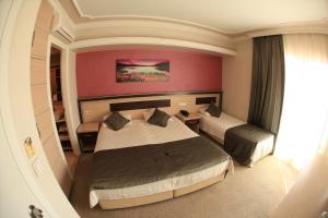 una camera d'albergo con due letti e una parete rossa di Vita Park Boutique Hotel a Konak
