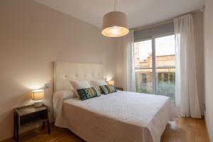 ein weißes Schlafzimmer mit einem Bett und einem großen Fenster in der Unterkunft Apartamento Bulevar 1 con parking gratuito in Castellón de la Plana