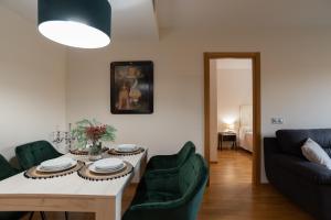 ein Wohnzimmer mit einem Tisch und grünen Stühlen in der Unterkunft Apartamento Bulevar 1 con parking gratuito in Castellón de la Plana