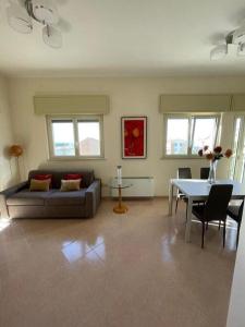een woonkamer met een bank en een tafel bij Casa Mediterranea: appartamento vista mare a soli 200m dalla spiaggia in Sperlonga
