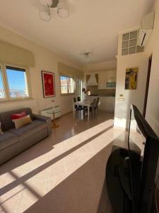 een woonkamer met een bank en een tafel bij Casa Mediterranea: appartamento vista mare a soli 200m dalla spiaggia in Sperlonga