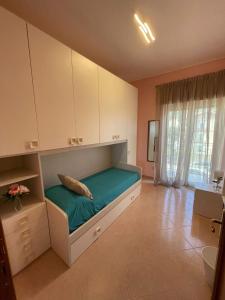 een slaapkamer met een bed met groene lakens en witte kasten bij Casa Mediterranea: appartamento vista mare a soli 200m dalla spiaggia in Sperlonga